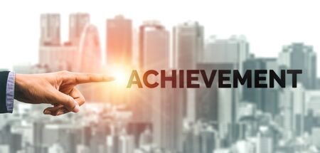 Creative business people hand pointing at word. Concept image of achievement and goal success.の写真素材