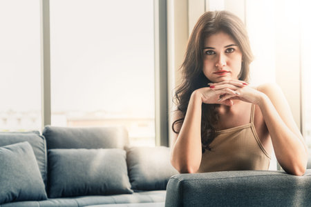 Beautiful relaxed business woman sitting on sofa couch in highrise office building tower.