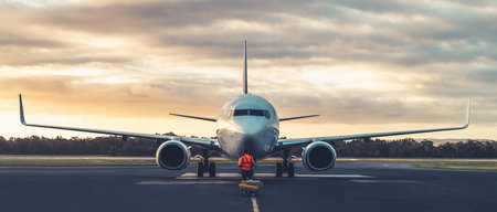 Sunset view of airplane on airport runway under dramatic sky in Hobart,Tasmania, Australia. Aviation...