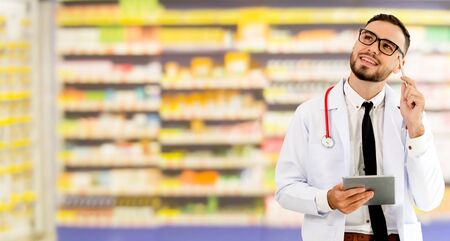 Pharmacist using tablet computer at the pharmacy. Medical healthcare and pharmaceutical staff service.の写真素材