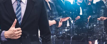 Business people group standing together with city office building background double exposure. Modern corporate job and human resources recruiting concept.の写真素材