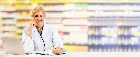 Pharmacist or doctor using laptop computer at the pharmacy room. Medical healthcare and pharmaceutical staff service.の写真素材