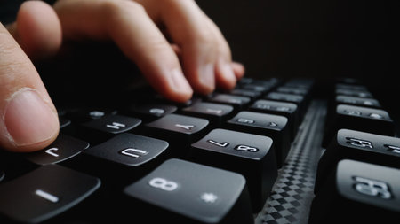 Close-up soft-focus finger typing on keyboard. Man hand using laptop computer in office. Programming...