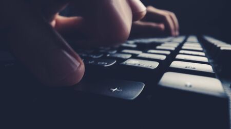 Close-up soft-focus finger typing on keyboard. Man hand using laptop computer in office. Programming and online marketing business concept.の写真素材
