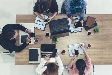 Top view of businessman executive in group meeting with other businessmen and businesswomen in modern office with laptop computer, coffee and document on table. People corporate business team concept.の写真素材