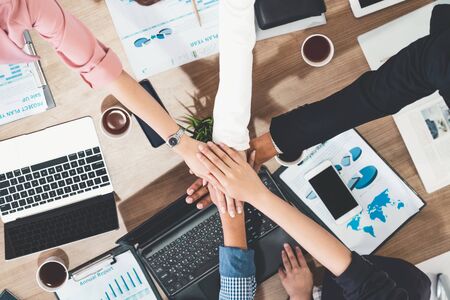 Businessmen and businesswomen joining hands in group meeting at multicultural office room showing teamwork, support and unity in business. Diversity workplace and corporate people working concept.の写真素材