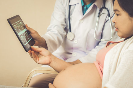 Happy pregnant woman visit gynecologist doctor at hospital or medical clinic for pregnancy consultant. Doctor examine pregnant belly for baby and mother healthcare check up. Gynecology concept.の写真素材