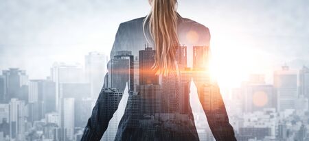 Double Exposure Image of Business Person on modern city background. Future business and communication technology concept. Surreal futuristic cityscape and abstract multiple exposure graphic interface.の写真素材