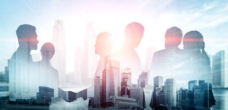 Double exposure image of many business people conference group meeting on city office building in background showing partnership success of business deal. Concept of teamwork, trust and agreement.の写真素材