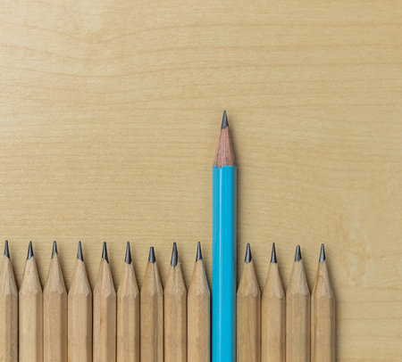 Different pencil standout from the others showing concept of unique business thinking different from...