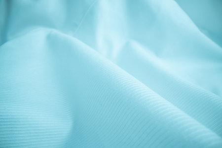 Shiny flowing cloth texture in macro shot. Wavy clean silk weave material. Textile abstract...