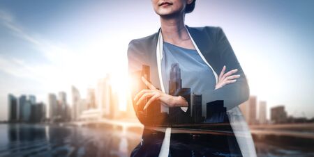 Double Exposure Image of Business Person on modern city background. Future business and communication technology concept. Surreal futuristic cityscape and abstract multiple exposure graphic interface.の写真素材