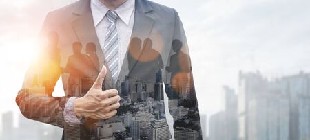 Double Exposure Image of Business Person on modern city background. Future business and communication technology concept. Surreal futuristic cityscape and abstract multiple exposure graphic interface.の写真素材