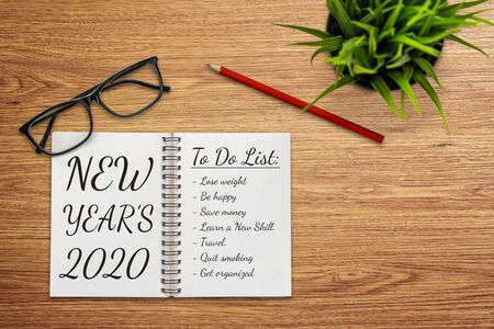 New Year Resolution Goal List 2020 - Business office desk with notebook written in handwriting about plan listing of new year goals and resolutions setting. Change and determination concept.の写真素材
