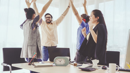 Successful business people group celebrating project success at office. Team winner and...