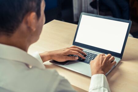 Business person or office worker using laptop computer while sitting at desk.の写真素材