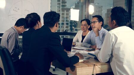 Asian business people discuss marketing strategy in group meeting at modern office. Business finance and teamwork concept.の写真素材