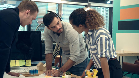 Creative business people group having conversation at office desk in modern workplace. Corporate...