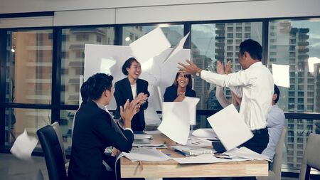 Successful Asian businessman and businesswoman celebrate project success while attending a group meeting. Victory and winner concept.の写真素材