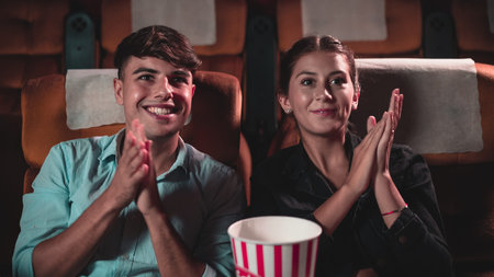 Man and woman applauding enthusiastically at the end of a performance and walk away
