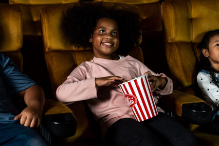 Three children having fun and enjoy watching movie in cinema