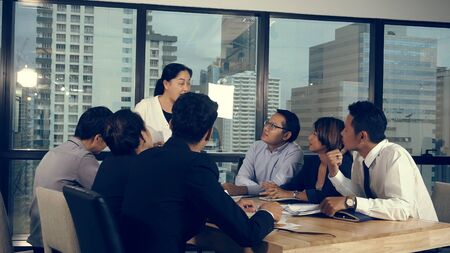 Asian business people discuss marketing strategy in group meeting at modern office. Business finance and teamwork concept.の写真素材