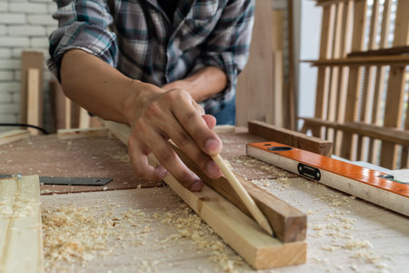 Carpenter working on wood craft at workshop to produce construction material or wooden furniture....