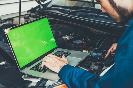 Professional mechanic providing car repair and maintenance service in auto garage. Car service business concept.の写真素材