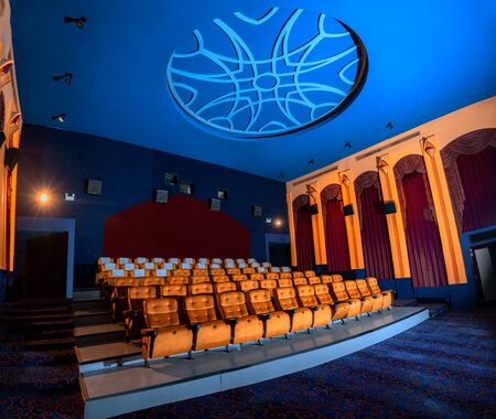 Large cinema theater interior with seat rows for audience to sit in movie theater premiere by cinematograph projector. The cinema theater is decorated in classical for luxury feel of movie watching.の写真素材
