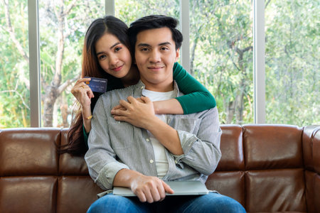 Young couple use credit card for online shopping on internet website at home. Number on the credit...