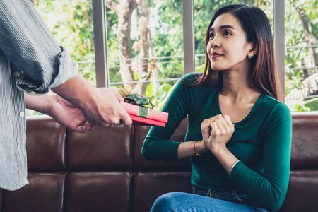 Happy couple giving gift present to celebrate anniversary. Marriage lifestyle, love and relationship concept.の写真素材