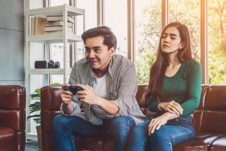 Young Asian couple suffers from computer games addiction. Family problem concept.の写真素材