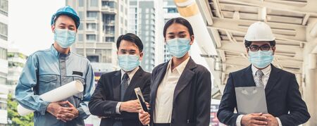 Confident business people with face mask protect from Coronavirus or COVID-19. Concept of help, support and collaboration together to overcome epidemic of Coronavirus or COVID-19 to reopen business.の写真素材