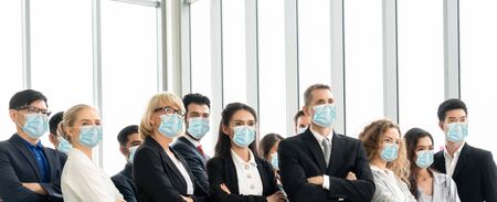 Confident business people with face mask protect from Coronavirus or COVID-19. Concept of help, support and collaboration together to overcome epidemic of Coronavirus or COVID-19 to reopen business.の写真素材