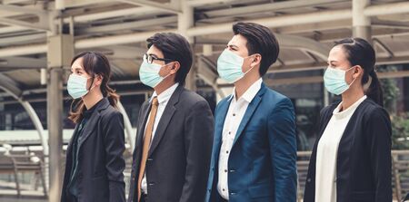 Confident business people with face mask protect from Coronavirus or COVID-19. Concept of help, support and collaboration together to overcome epidemic of Coronavirus or COVID-19 to reopen business.の写真素材