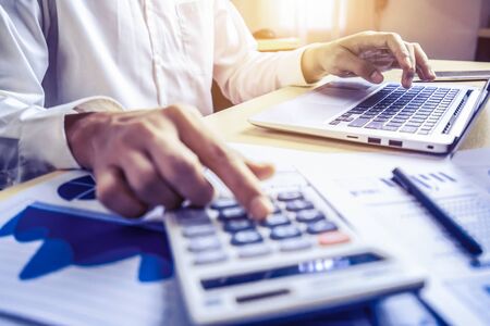 Businessman accountant or financial expert analyze business report graph and finance chart at corporate office. Concept of finance economy, banking business and stock market research.の写真素材