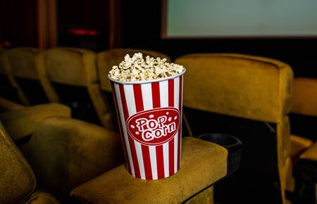 A row of yellow seat with popcorn on chair in the movie theaterの写真素材