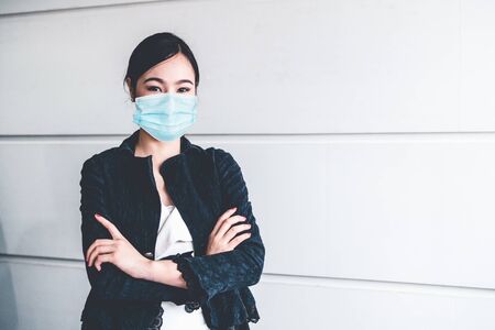 Office worker with face mask quarantine from coronavirus or COVID-19. Concept of protective working environment to reopen business and stop spreading of coronavirus or COVID-19.の写真素材