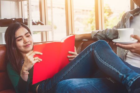 Happy Asian couple drink coffee at home. Love relationship and lifestyle concept.の写真素材