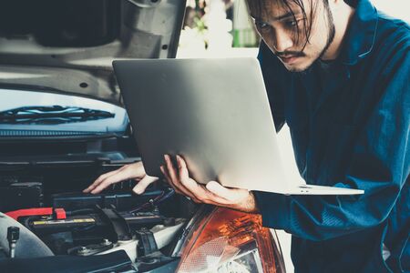 Professional mechanic providing car repair and maintenance service in auto garage. Car service business concept.の写真素材