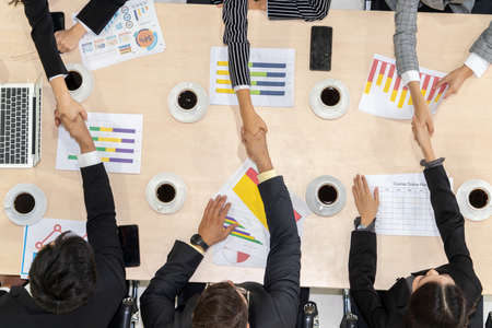 Group business people handshake at meeting table in office together with confident shot from top view . Young businessman and businesswoman workers express agreement of investment deal.の写真素材
