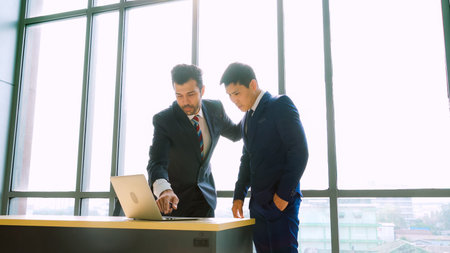 Two business people talk project strategy at office meeting room. Businessman discuss project...