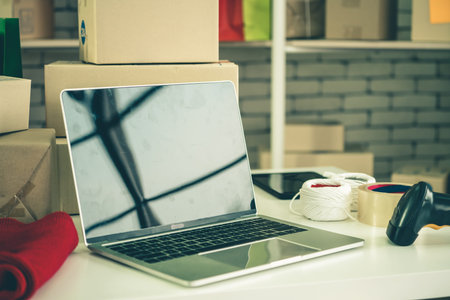 Laptop computer with empty screen on shipping box background. Concept of online retail store,...