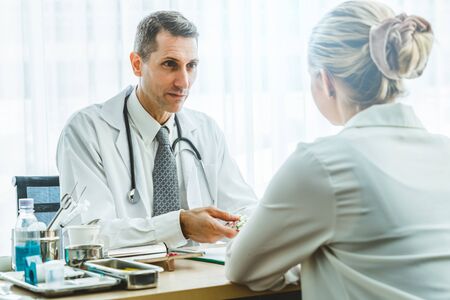 Doctor in professional uniform examining patient at hospital or medical clinic. Health care , medical and doctor staff service concept.の写真素材