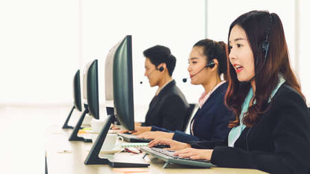 Business people wearing headset working in officeの写真素材