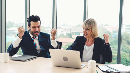 Two happy business people celebrate at officeの写真素材
