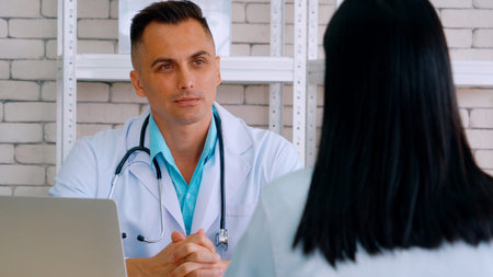 Doctor in professional uniform examining patient at hospitalの写真素材
