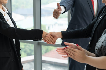 Business people handshake in corporate office showing professional agreement on a financial deal...