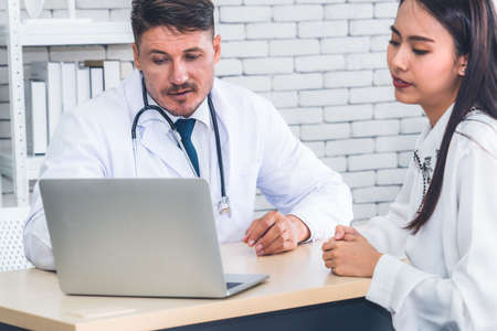 Doctor in professional uniform examining patient at hospitalの写真素材