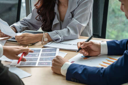 Smart businessman and businesswoman talking discussion in group meeting at office table in a modern office interior. Business collaboration strategic planning and brainstorming of coworkers.の写真素材